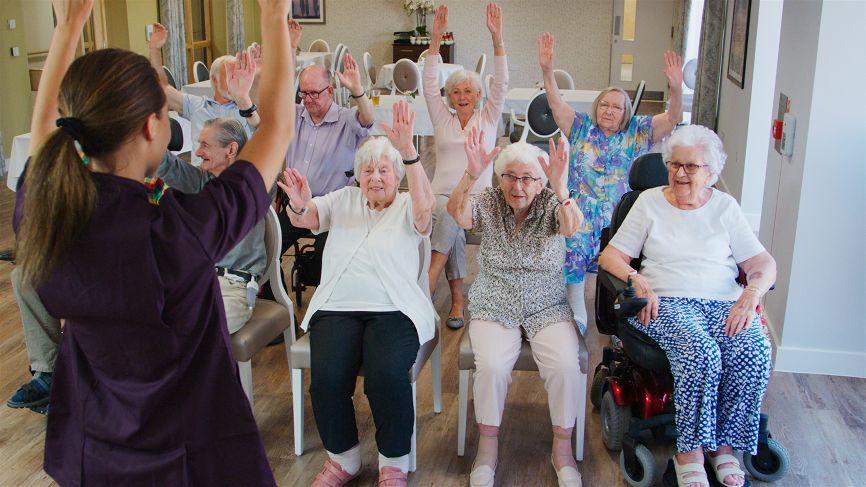 carer leading fitness class with older people
