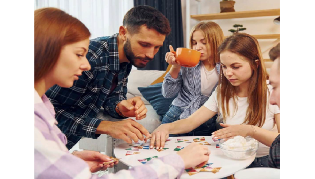Picture of young people sitting round a table playing a puzzle game